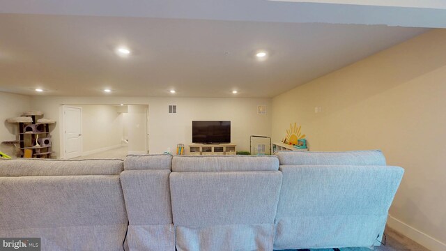 carpeted living room with recessed lighting and baseboards