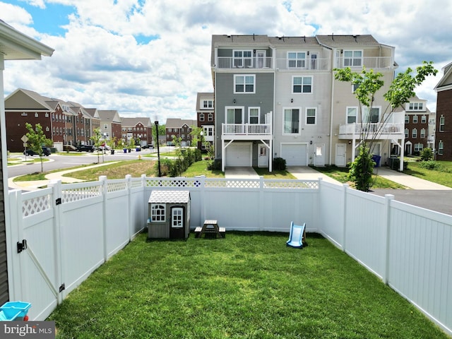 view of yard featuring a residential view and a garage