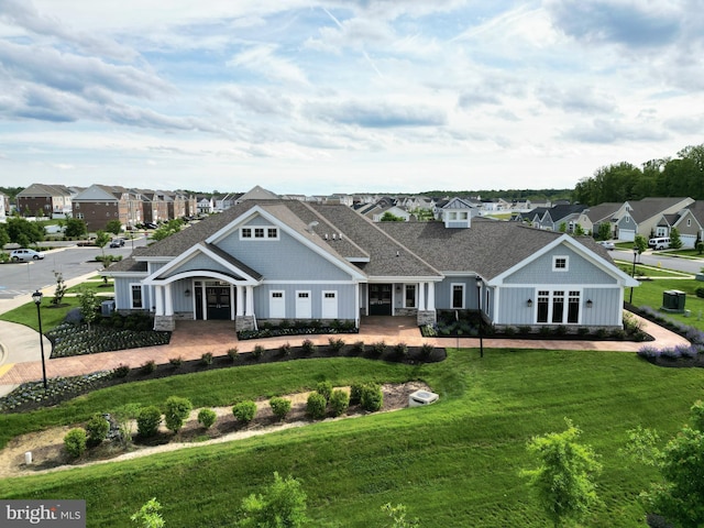 view of front of house featuring a residential view, a front yard, roof with shingles, and board and batten siding