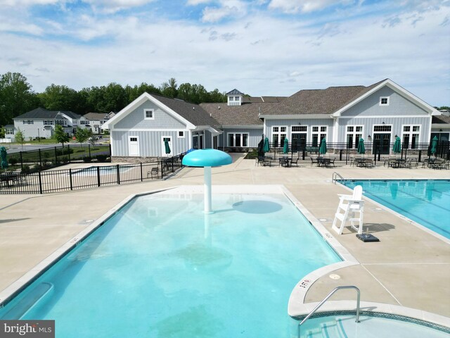 community pool featuring fence and a patio