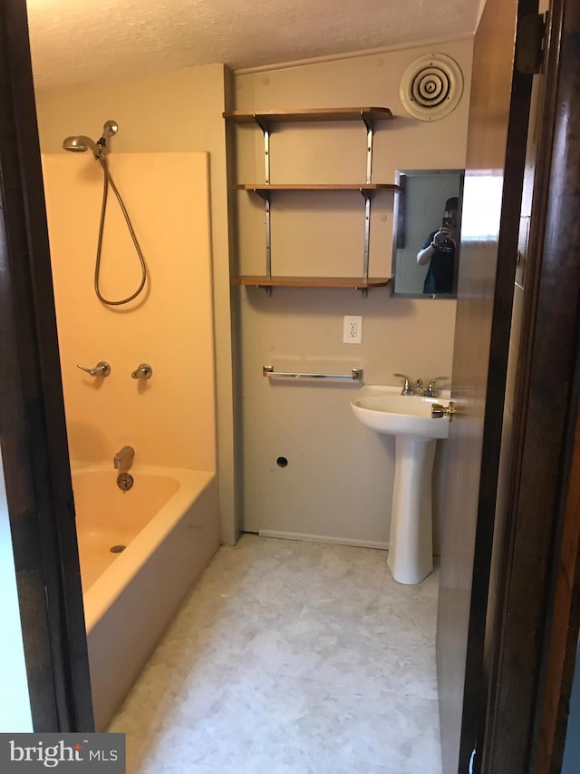 bathroom featuring shower / tub combination, a sink, and visible vents
