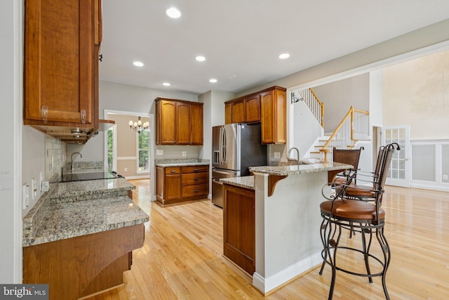 301 Gentle Breeze Cir, Fredericksburg, VA 22406 - kitchen featuring a peninsula, a breakfast bar area, light wood-style flooring, stainless steel refrigerator with ice dispenser, and recessed lighting