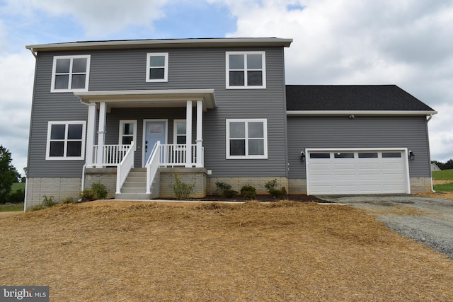 view of front of home with an attached garage, aphalt driveway, and covered porch