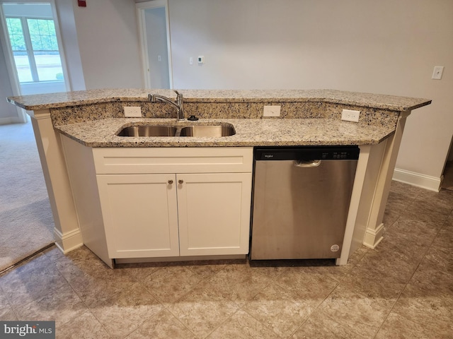 kitchen with dishwasher, a sink, white cabinetry, light stone countertops, and baseboards