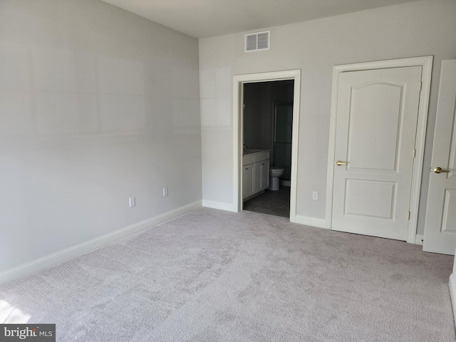 unfurnished bedroom featuring carpet, baseboards, and ensuite bathroom