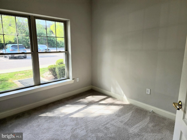empty room featuring carpet and baseboards