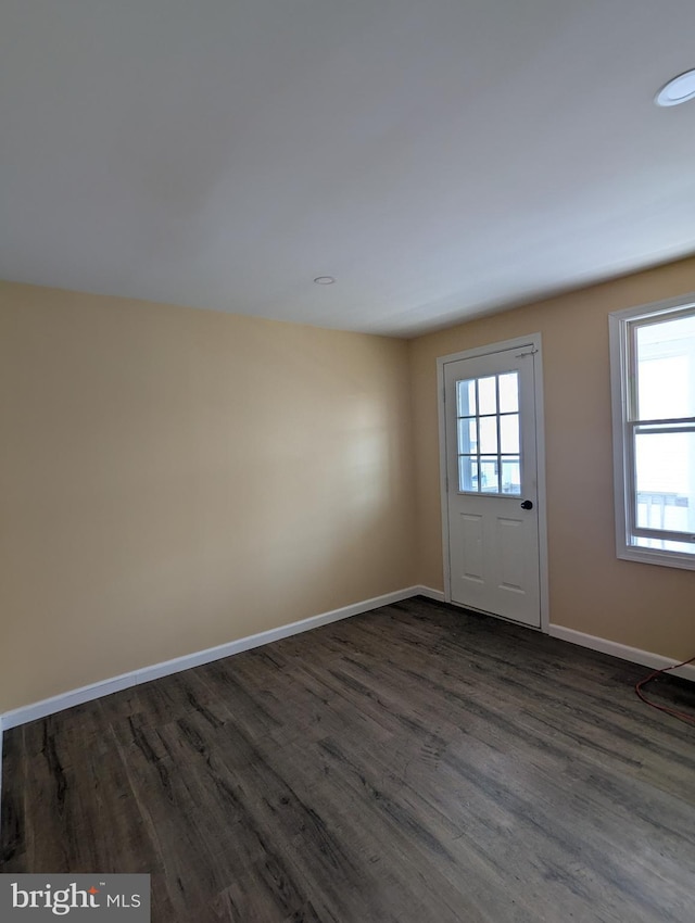 interior space featuring recessed lighting, baseboards, and dark wood finished floors