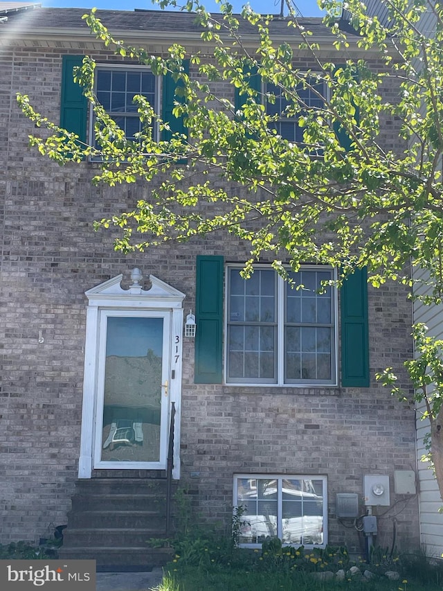view of exterior entry with brick siding