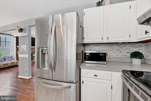 7707 W Dr, Glen Burnie, MD 21060 - kitchen with appliances with stainless steel finishes, wood finished floors, light countertops, backsplash, and white cabinetry