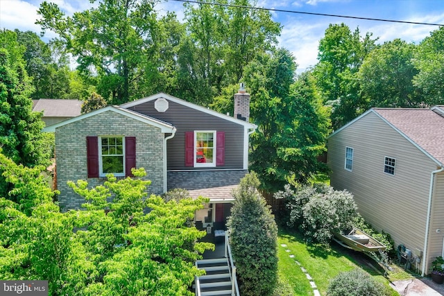 7707 W Dr, Glen Burnie, MD 21060 - view of front of home featuring a chimney, brick siding, and view of scattered trees