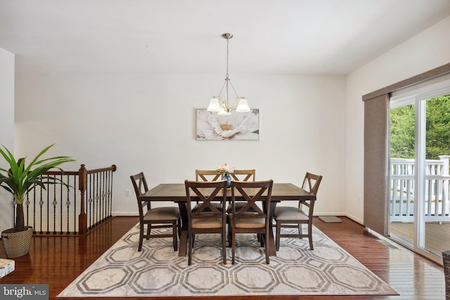 dining area featuring baseboards, a chandelier, and wood finished floors