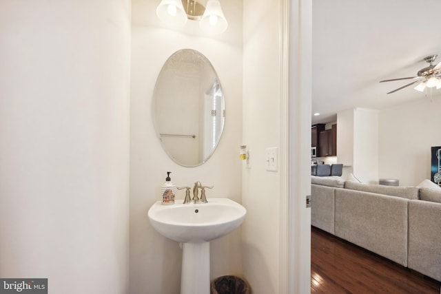 bathroom with a sink, ceiling fan with notable chandelier, and wood finished floors