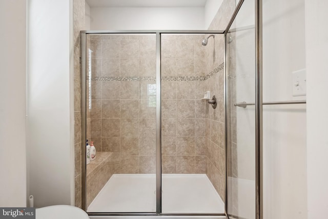 bathroom with a shower stall and toilet