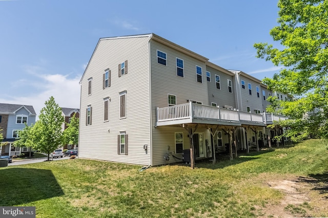 rear view of house featuring a yard and a deck