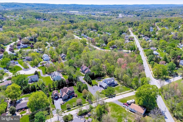 drone / aerial view featuring a residential view and a wooded view