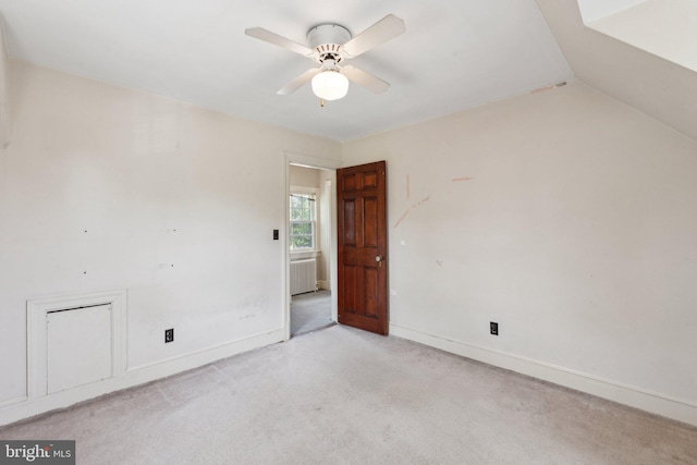 empty room featuring ceiling fan, light colored carpet, and baseboards