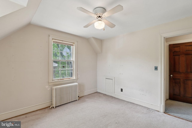 bonus room with a ceiling fan, radiator, carpet, and vaulted ceiling