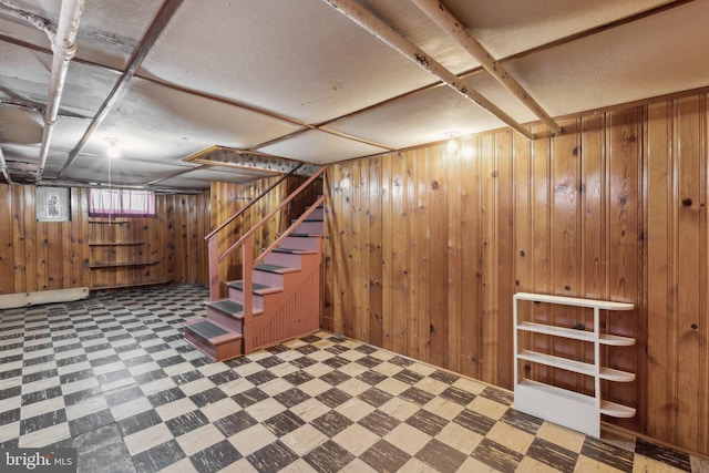 below grade area with stairway, tile patterned floors, and wood walls