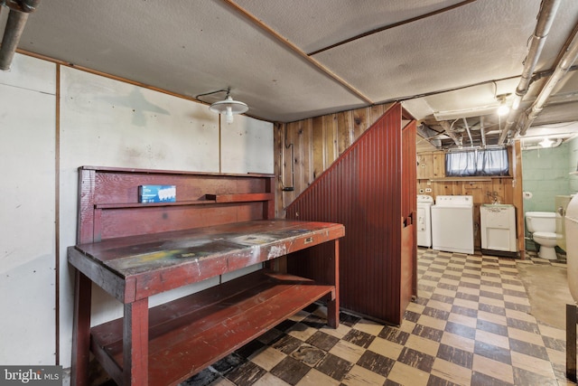 below grade area with washer and clothes dryer, tile patterned floors, and wooden walls