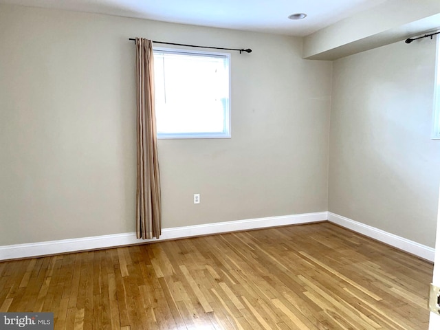 spare room featuring light wood-style floors and baseboards
