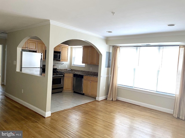 kitchen featuring baseboards, light wood-style flooring, appliances with stainless steel finishes, and dark countertops