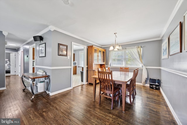 dining space with baseboards, ornamental molding, wood-type flooring, and a notable chandelier