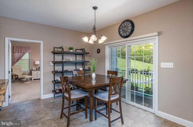 dining room featuring baseboards and a chandelier