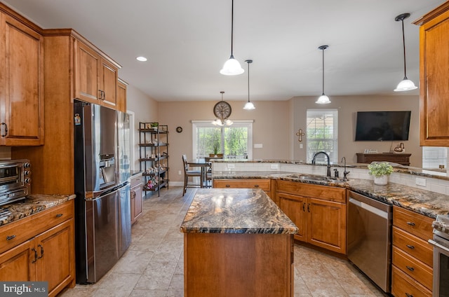 kitchen featuring a sink, appliances with stainless steel finishes, and brown cabinets