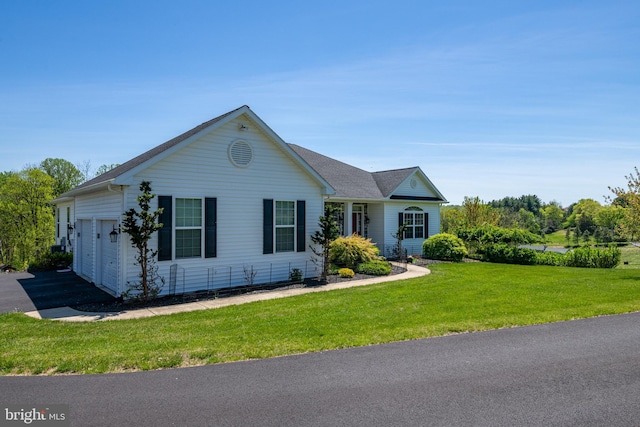single story home featuring driveway, a front yard, and a garage