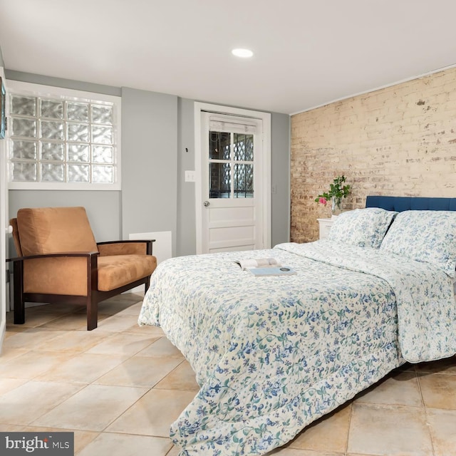 tiled bedroom featuring recessed lighting and brick wall