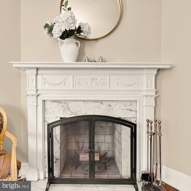 room details featuring baseboards and a fireplace