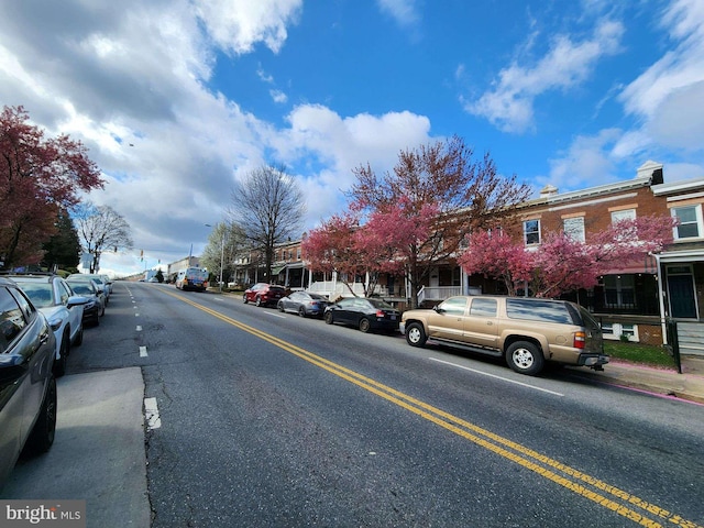 view of road featuring a residential view, sidewalks, and street lights