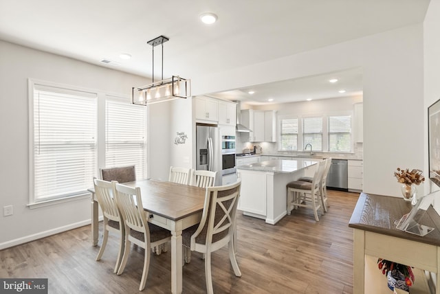 dining space with visible vents, baseboards, light wood-type flooring, recessed lighting, and a notable chandelier