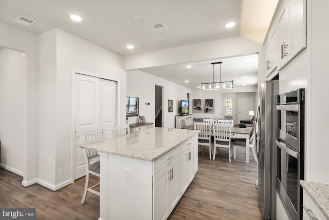 kitchen featuring visible vents, recessed lighting, white cabinetry, and wood finished floors