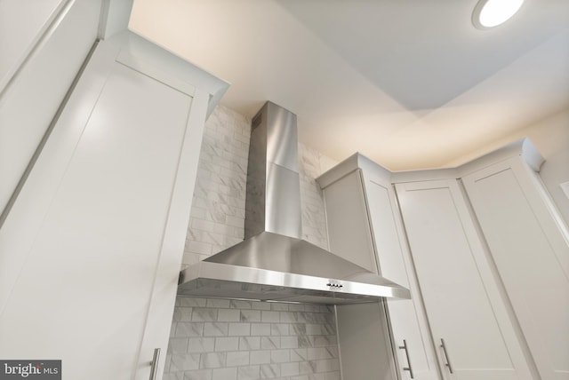 room details with light countertops, backsplash, and wall chimney range hood