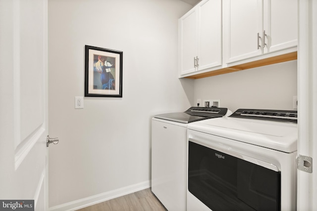 washroom featuring separate washer and dryer, baseboards, light wood-style flooring, and cabinet space