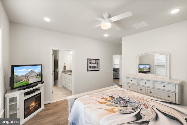 bedroom featuring visible vents, recessed lighting, light wood-style flooring, and ensuite bathroom