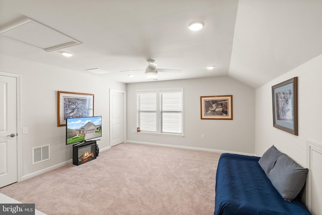 sitting room with baseboards, light carpet, lofted ceiling, and visible vents