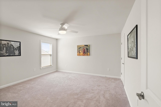 carpeted empty room featuring baseboards and ceiling fan