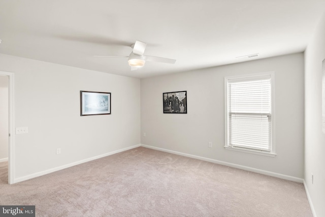 unfurnished room featuring light colored carpet and baseboards