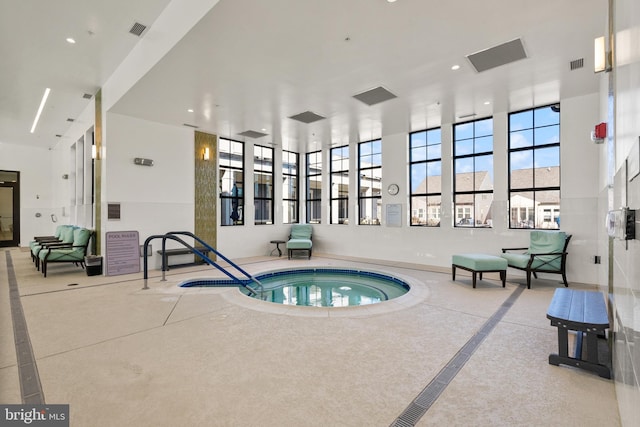 view of swimming pool with an indoor hot tub