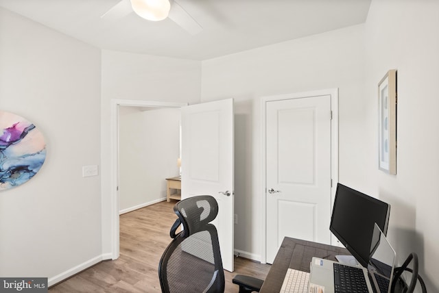 office featuring light wood-style floors, baseboards, and a ceiling fan