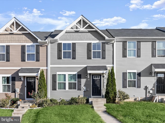 townhome / multi-family property featuring a front lawn