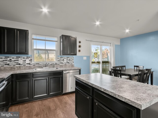 kitchen featuring a sink, appliances with stainless steel finishes, dark cabinets, and a wealth of natural light