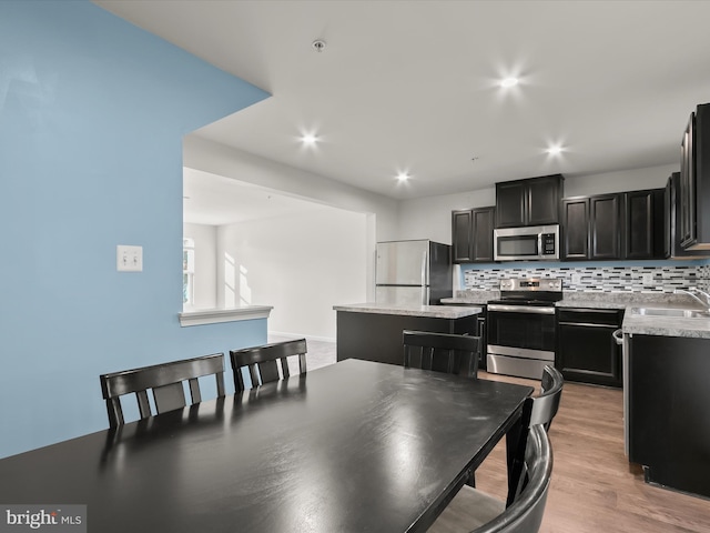 dining space with recessed lighting and light wood finished floors