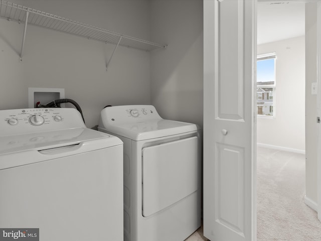 laundry area with light colored carpet, washer and clothes dryer, baseboards, and laundry area