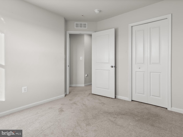 unfurnished bedroom with visible vents, carpet flooring, baseboards, and a closet