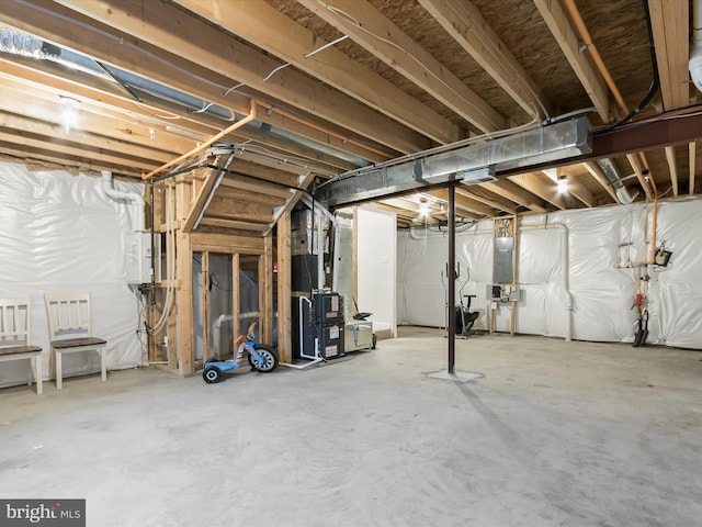 unfinished basement featuring heating unit and electric panel