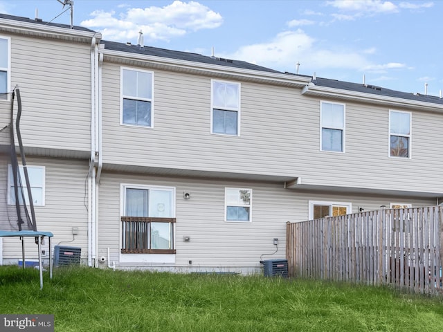 rear view of house featuring fence and cooling unit