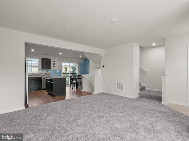 living room with recessed lighting, baseboards, dark carpet, and visible vents